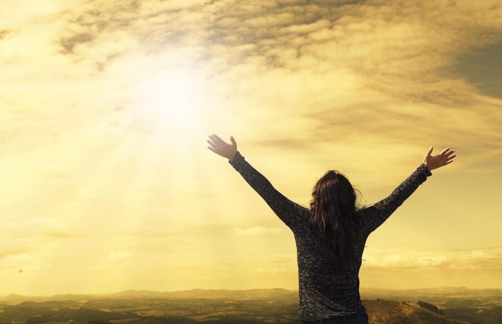 woman, sky, sunlight, arms, open arms, sunbeams, sunrays, nature, clouds, worship, freedom, happiness, relieved, prayer, praise, success, joy